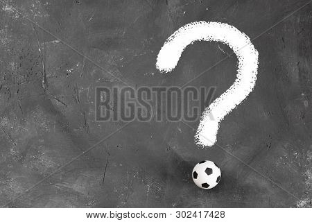 Quastion Mark Made Of Small Football Ball And White Chalk Line On Dark Textured Blackboard Backgroun