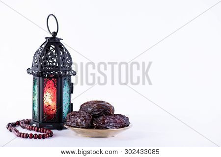 Ramadan Food And Drinks Concept. Ramadan Lantern With Arabian Lamp, Wood Rosary, Dates Fruit And Lig