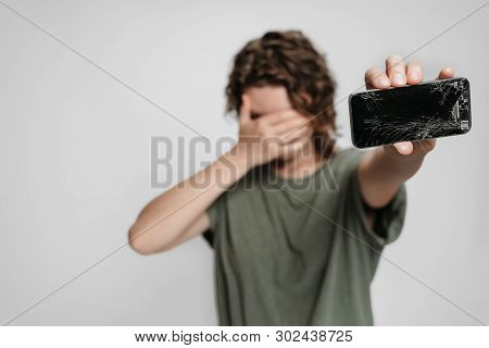 Frustrated Upset Person Holding Her Broken Smartphone With Damaged Screen Glass. Smartphone Repair C