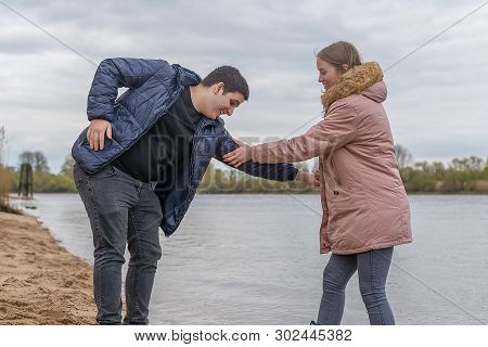 Young Couple Has Fun And Play Around At The Water
