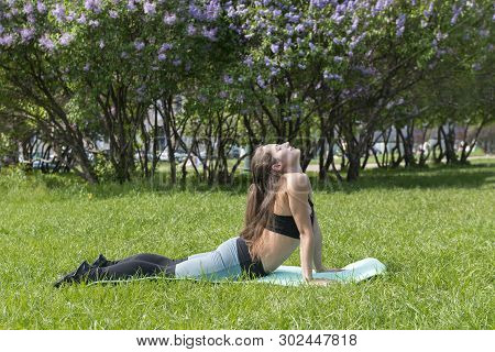 1 White Slender Girl With Long Hair Doing Yoga On The Grass In The Park, Girl Doing Exercise On The 