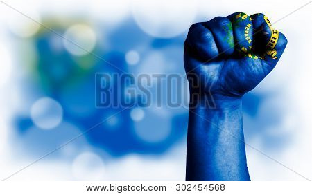 Flag State Of Nevada Painted On Male Fist, Strength, Power, Concept Of Conflict. On A Blurred Backgr
