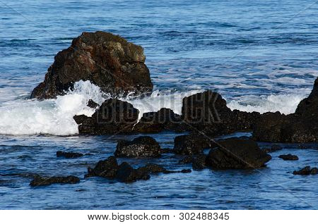 Breaking White Water Over Rocks In Pacific Ocean, Hawaii.  Blue Ocean Water, White Foam, White Spray