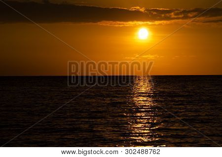 Golden Sunset Over Ocean.  Low Clouds, Yellow Orange Setting Sun Over Pacific Ocean In Big Island, H
