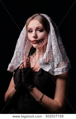Makeup For The Celebration Of Halloween. The Girl In The Image Of A Terrible Nun With A Bloody Mouth
