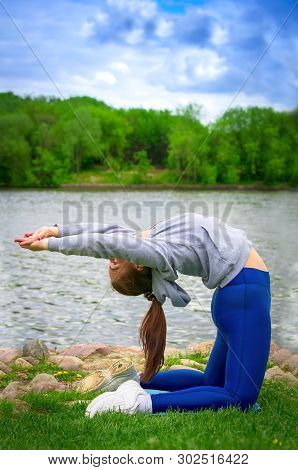 Young Girl Goes In For Sports In Nature. Healthy Lifestyle.flaxible Child Doing Joga Poses Bridge St