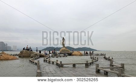 Zhuhai, China - May 2019: Tourists Visiting The Famous Fisher Girl In Zhuhai, China
