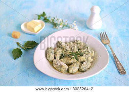 Gnocchi Or Dumplings With Nettle Or Spinach On A White Plate On A Light Blue Background. Served With