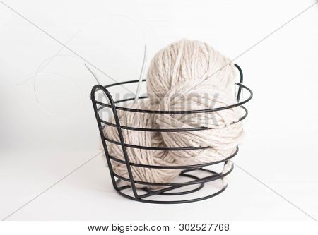 Wool Yarn In Coils And Baals Of Wool With Knitting Needles In Basket