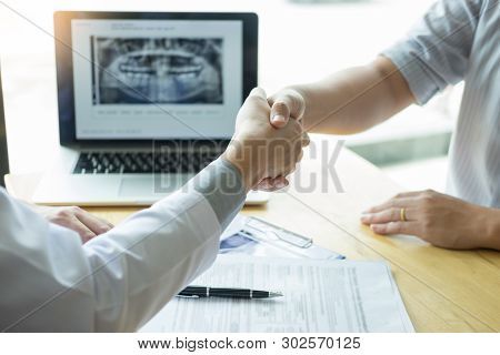 Dental Hygienist Demonstrating And Showing A Dummy Jaw To Chack-up Or Healing Teeth  Patient