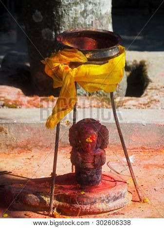 Shrine covered in vermillion to worship Goddess Kali. Red pigment powder on statue, part of Kali Shrine on the mountain in Dhulikhel, Nepal