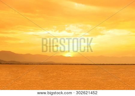 Beautiful Of Sunset At Phayao Lake Or Kwan Phayao With Big Mountain And Clouds. Orange Sky With Sunl
