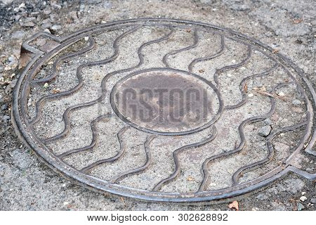 Metal Cover Of The City Sewer, City Shot In The Summer On A Sunny Day Close-up