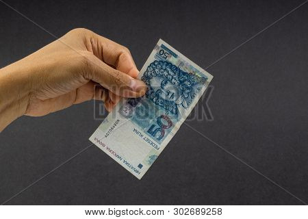 Hand Holding Fifty Croatian Kuna Or Sto Kuna Bank Notes On Black Background. Financial Concept And S