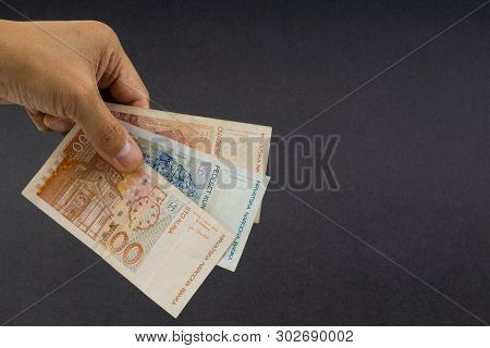 Hand Holding Fifty Croatian Kuna Or Sto Kuna Bank Notes On Black Background. Financial Concept And S