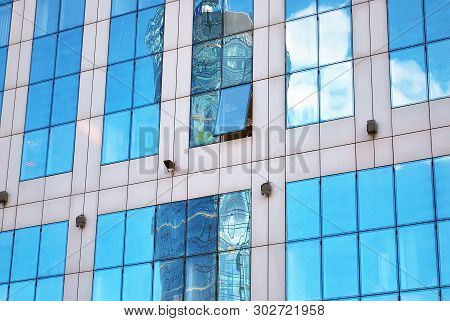 New Office Building In Business Center. Wall Made Of Steel And Glass With Blue Sky.