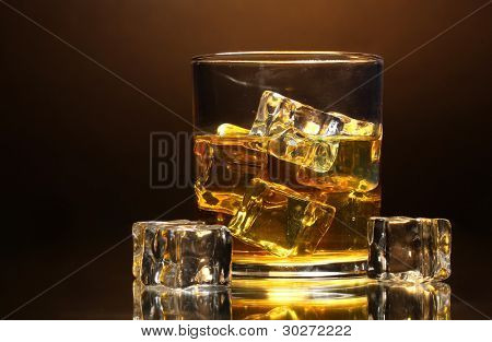verre de whisky et de la glace sur fond marron