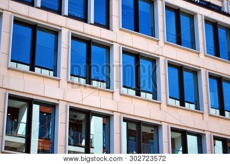 New office building in business center. Wall made of steel and glass with blue sky.