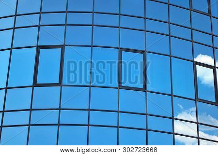 New Office Building In Business Center. Wall Made Of Steel And Glass With Blue Sky.