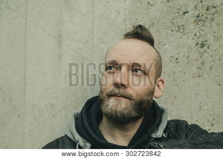 Happy Inspired Bearded Man Looking Up In Front Of A Wall