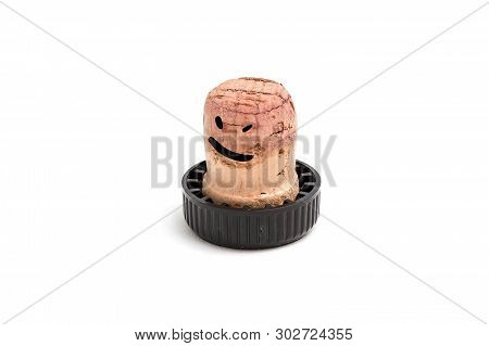 Cork For Wine With A Black Plastic Hat On Which Is Drawn A Drunken Smile And Eyes. Isolated On White