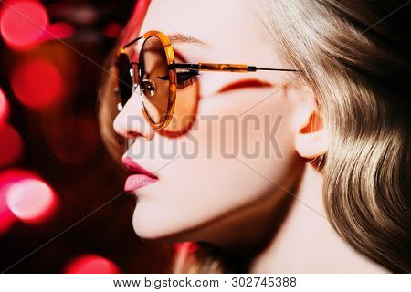 A close up portrait of a confident lady wearing cutglasses. Beauty, make-up, style.
