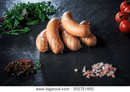 Top View On Pile Of Short Sausages With Rucola And Tomatoes