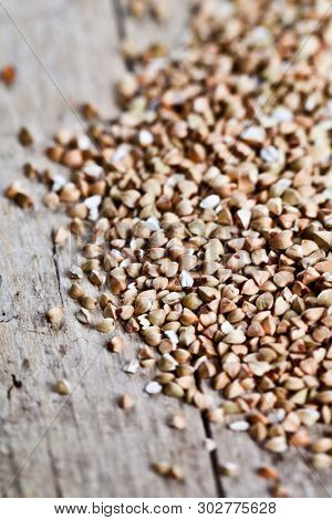 Fresh green dry buckwheat seads closeup on rustic wooden background. Buckwheat texture with copy space.