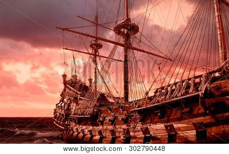 Re-production of a galleon in public site in Genova, Italy, stormy sky 
