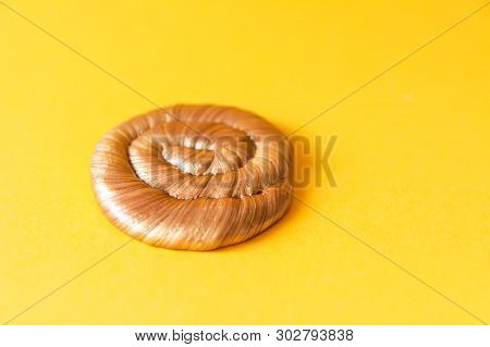 Golden Plasticine Soft Stretchable Texture On Yellow Background. Anti-stress Toy For Kids Activities
