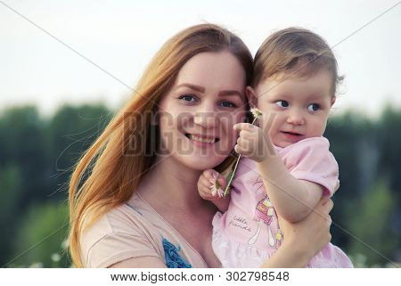 Young Mother With Her Daughter In Nature