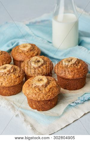 Banana Muffin, Side View, Vertical. Cupcakes On Blue Napkin With Milk In A Bittle, White Concrete Ta