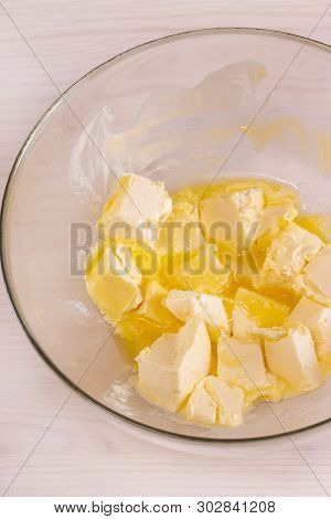 Slices Of Butter Melt, Soft Butter Base For The Dough, A Transparent Bowl Top View, Vertical