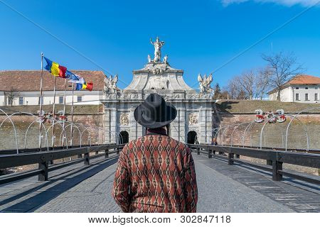 A Tourist Young Man With A Hat Admiring A Fortress Gate Entrance. A Man Admiring The 3Rd Gate Of The