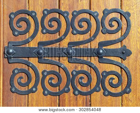 Decorative Metal Hinge On An Old Wooden Door