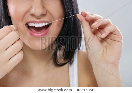 Zbliżenie kobiety nicią dentystyczną zęby z nici dentystyczne