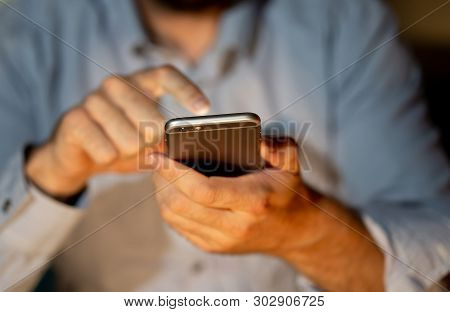 Close Up Of Young Man Hands Using Smartphone In Phone Addiction And Mobile Gaming Concept