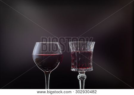 Rose Wine. Red Wine In Two Wine Glasses Over Dark Background With Rays Of Light.