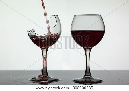 Wine. Red Wine Pouring Into Broken Wine Glass On The Wet Surface. Rose Wine Pour. Close Up Shot. Whi