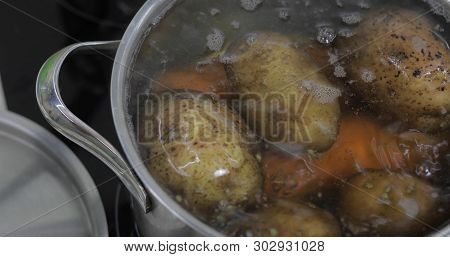 Hot Boiling Pan With Vegetables Potatoes And Carrots. Cooking In A Pan On The Home Kitchen