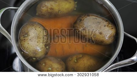 Hot Boiling Pan With Vegetables Potatoes And Carrots. Cooking In A Pan On The Home Kitchen