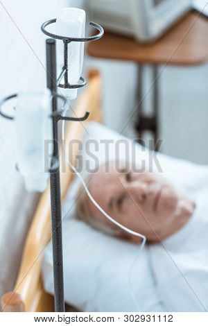 Selective Focus Of Sick Senior Man Lying On Bed In Clinic
