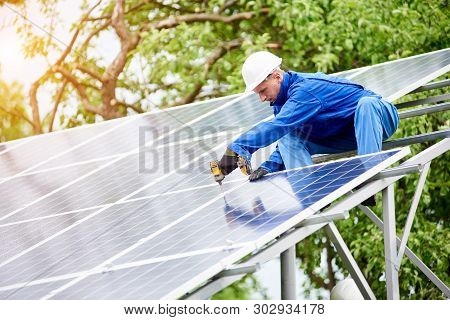 Young Construction Worker Connects Photo Voltaic Panel To Solar System Using Screwdriver On Bright S