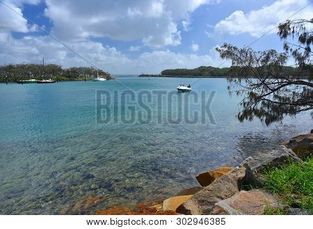 Boat On Mooloolah River On A Sunny But Cloudy Day. Rock Wall Along Mooloolah River (sunshine Coast, 