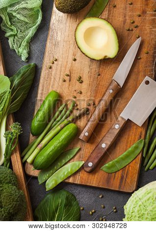 Assorted Green Toned Raw Organic Vegetables In Wooden Box On Dark Stone Background. Avocado, Cabbage