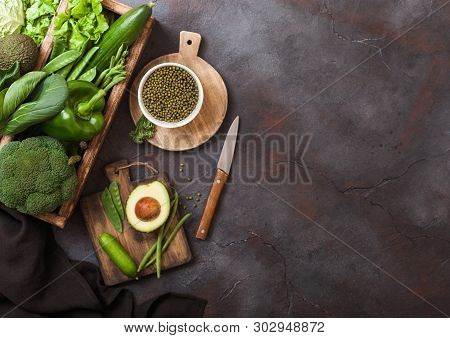 Assorted Green Toned Raw Organic Vegetables In Wooden Box On Dark Stone Background. Avocado, Cabbage