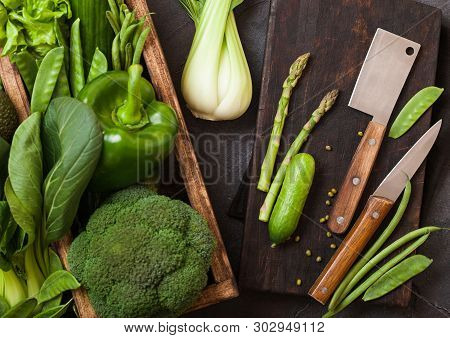 Assorted Green Toned Raw Organic Vegetables In Wooden Box On Dark Stone Background. Avocado, Cabbage