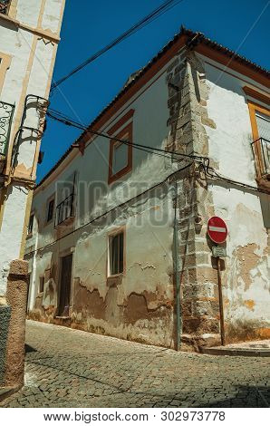 Elvas, Portugal - July 7, 2018. Old Houses With Peeling Plaster And No Entry Signpost On Sunny Day A