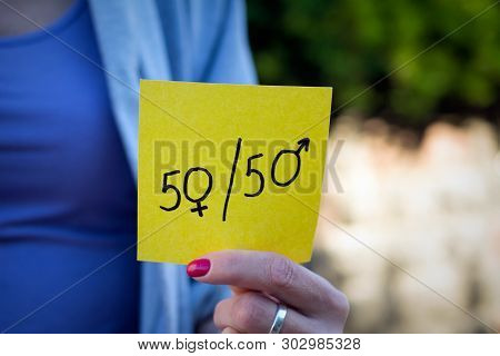 Gender Equality Concept, A Piece Of Paper With A Female And A Male Symbol In A Woman's Hand