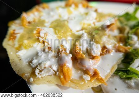 Sope With Sauce, Chicken, And Sour Cream On A White Plate